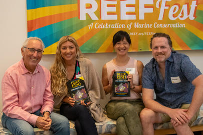 A group of four people smiling and holding fish behavior books.