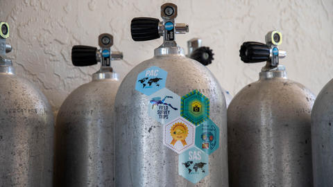 Colorful hexagonal stickers on a scuba tank, representing various "conservation challenges".